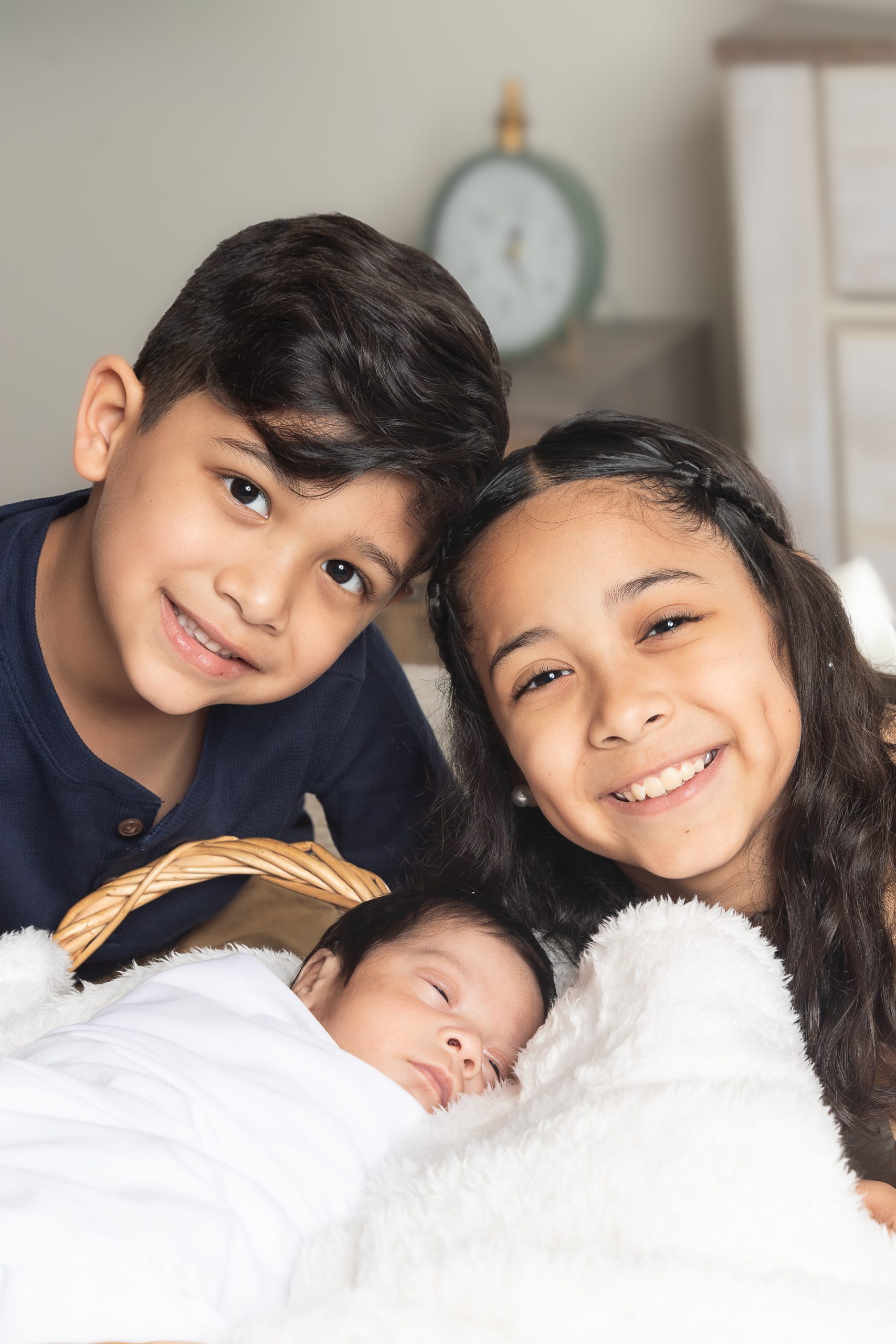 Velasquez -3 Family of five smiling outdoors in casual jeans with trees and greenery background.